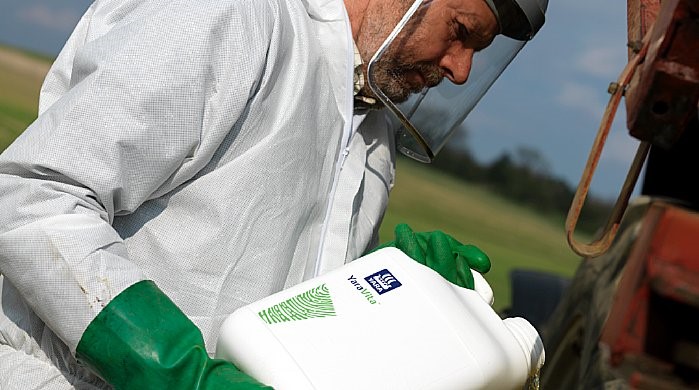 Homem com viseira fazendo mistura de YaraVita em tanque